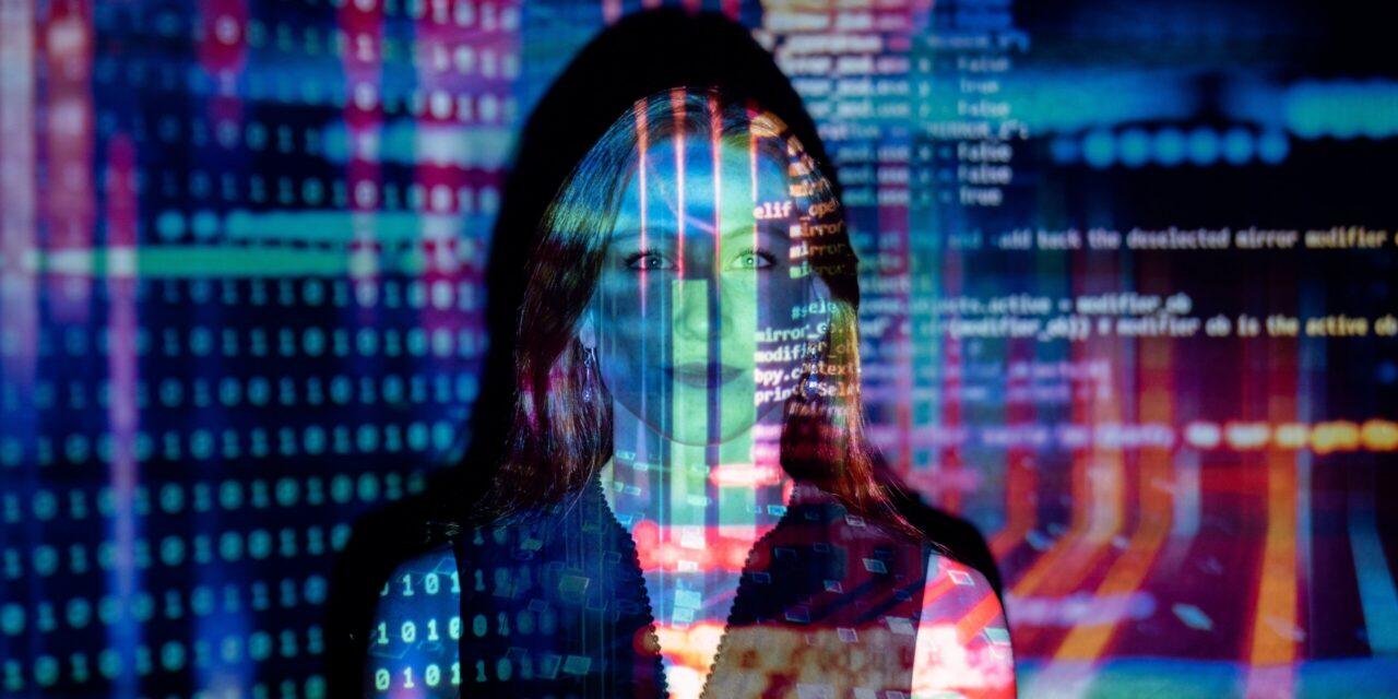 AI tech tools for staffing make it easy for staffing agencies to save time and money. This photo is of a person in a dark room with colorful lines of code being projected over their face and upper body.