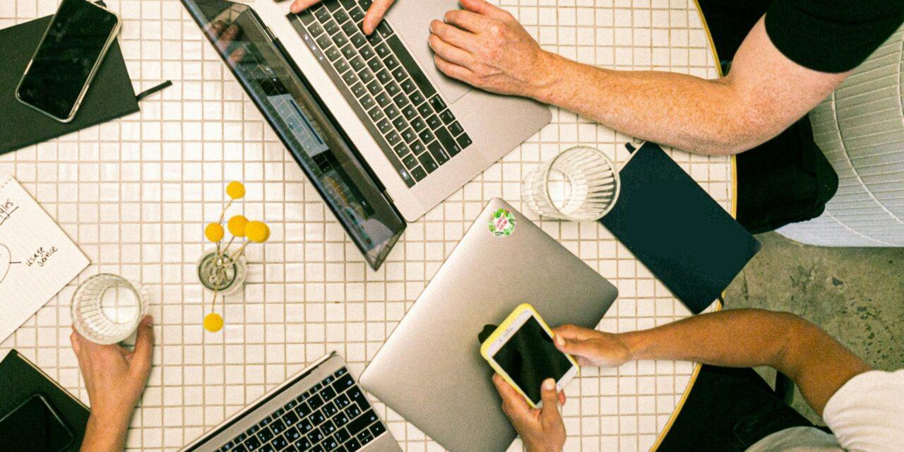 a team of people sits at a conference table to brainstorm marketing for staffing agencies