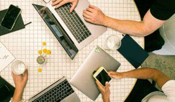 a team of people sits at a conference table to brainstorm marketing for staffing agencies