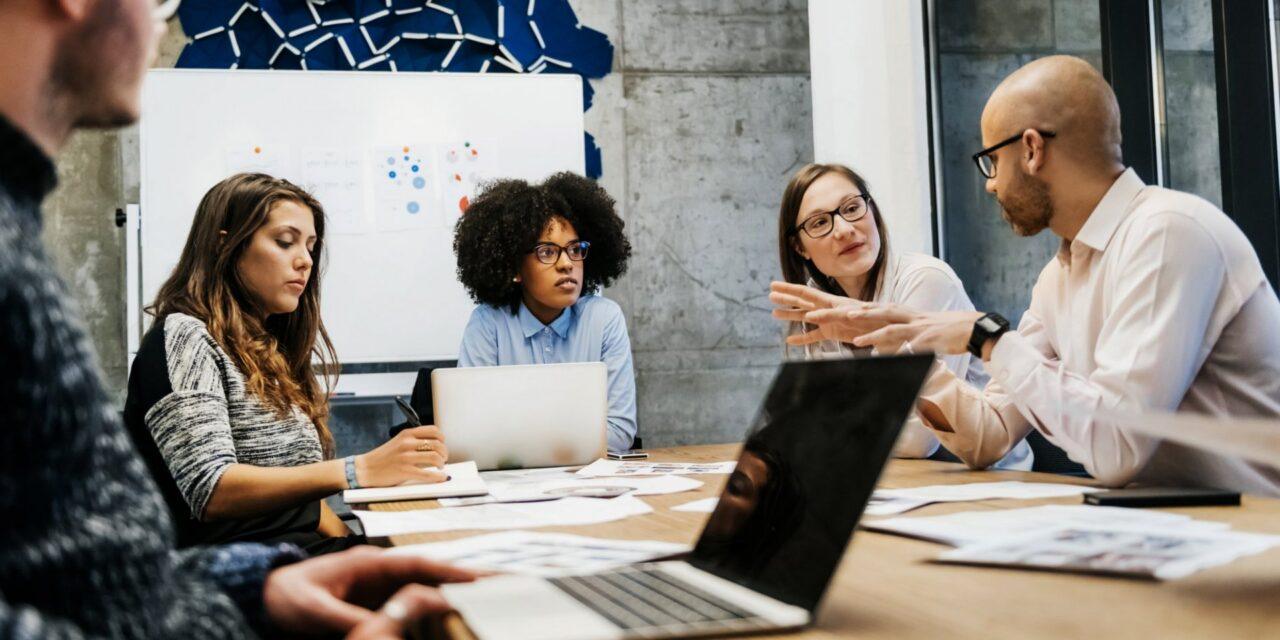 a group of entrepreneurs discuss the plan around a conference table