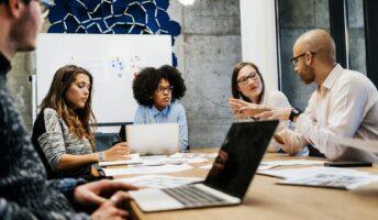 a group of entrepreneurs discuss the plan around a conference table