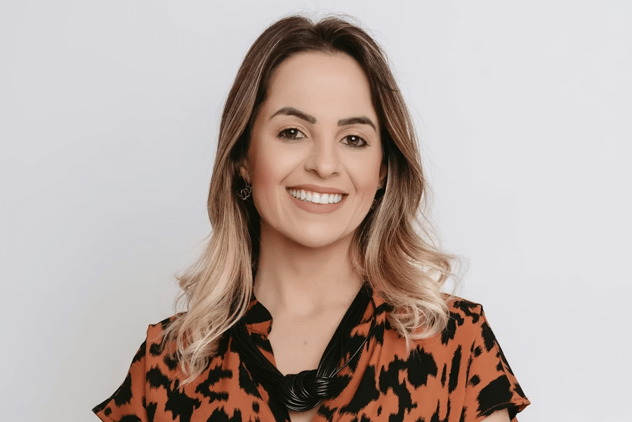 Smiling woman with long blonde-tipped hair in a leopard print blouse